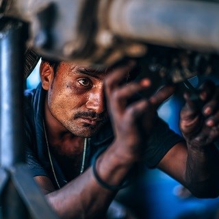 Car mechanic working under the car