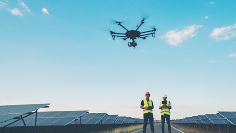 Kiwa inspectors performing on-site drone inspection of solar panels on a solar farm using a drone