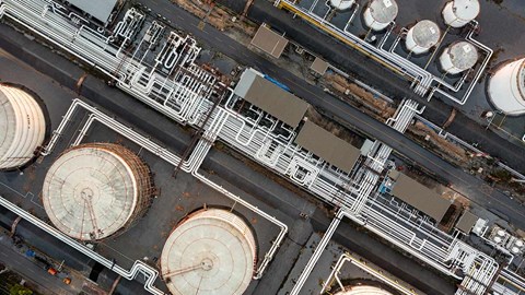 Cisterner och rörsystem på ett oljeraffinaderi, fotograferat från ovan. 