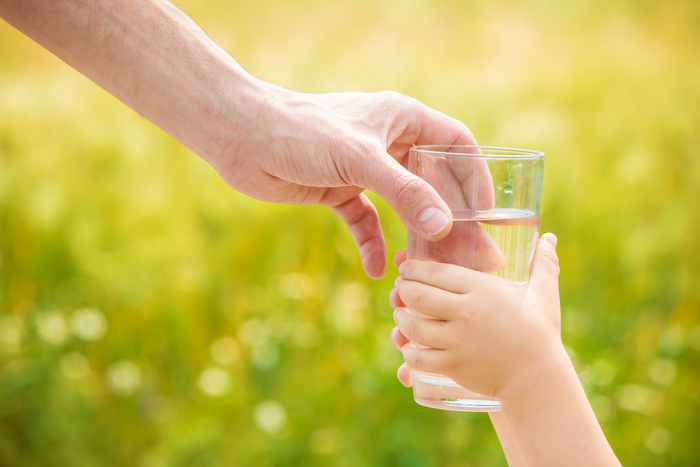 Kiwa - Parent presenting glass of water to child
