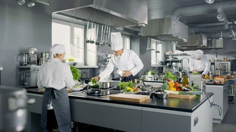 Chefs in a restaurant kitchen which can be auditing by Kiwa