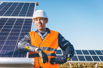 Worker leaning on solar panels