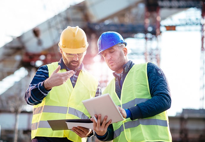 Two men discussing plans at construction site