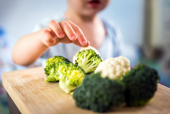 Child takes broccoli florets