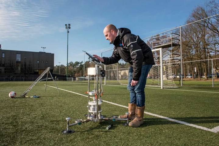 Man inspecting quality of football field with ISA equipment