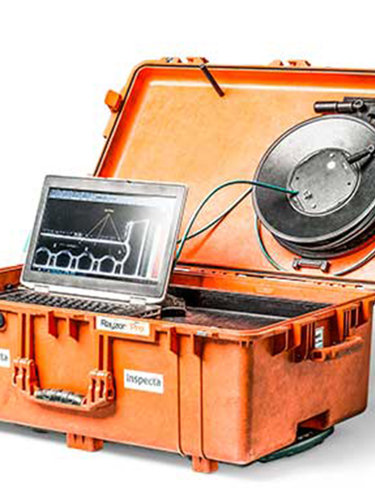Orange inspektionsväska för DDA med öppen lock, bärbar dator och rund industrikomponent med kablar.