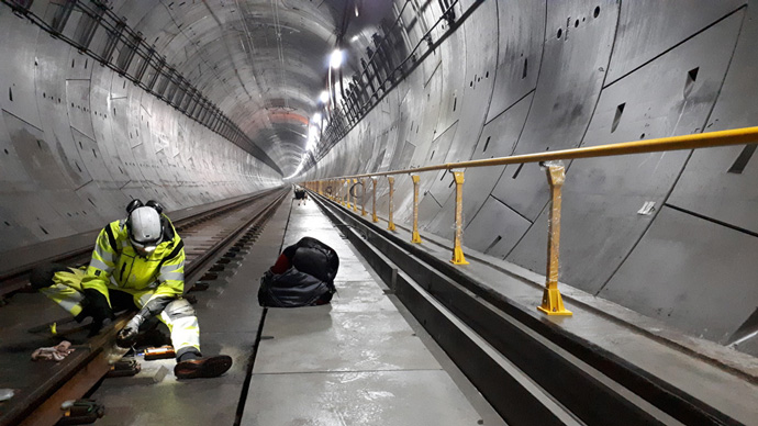 Kiwa inspector kneeling in Nordic region's longest railway tunnel performing an ultrasonic test