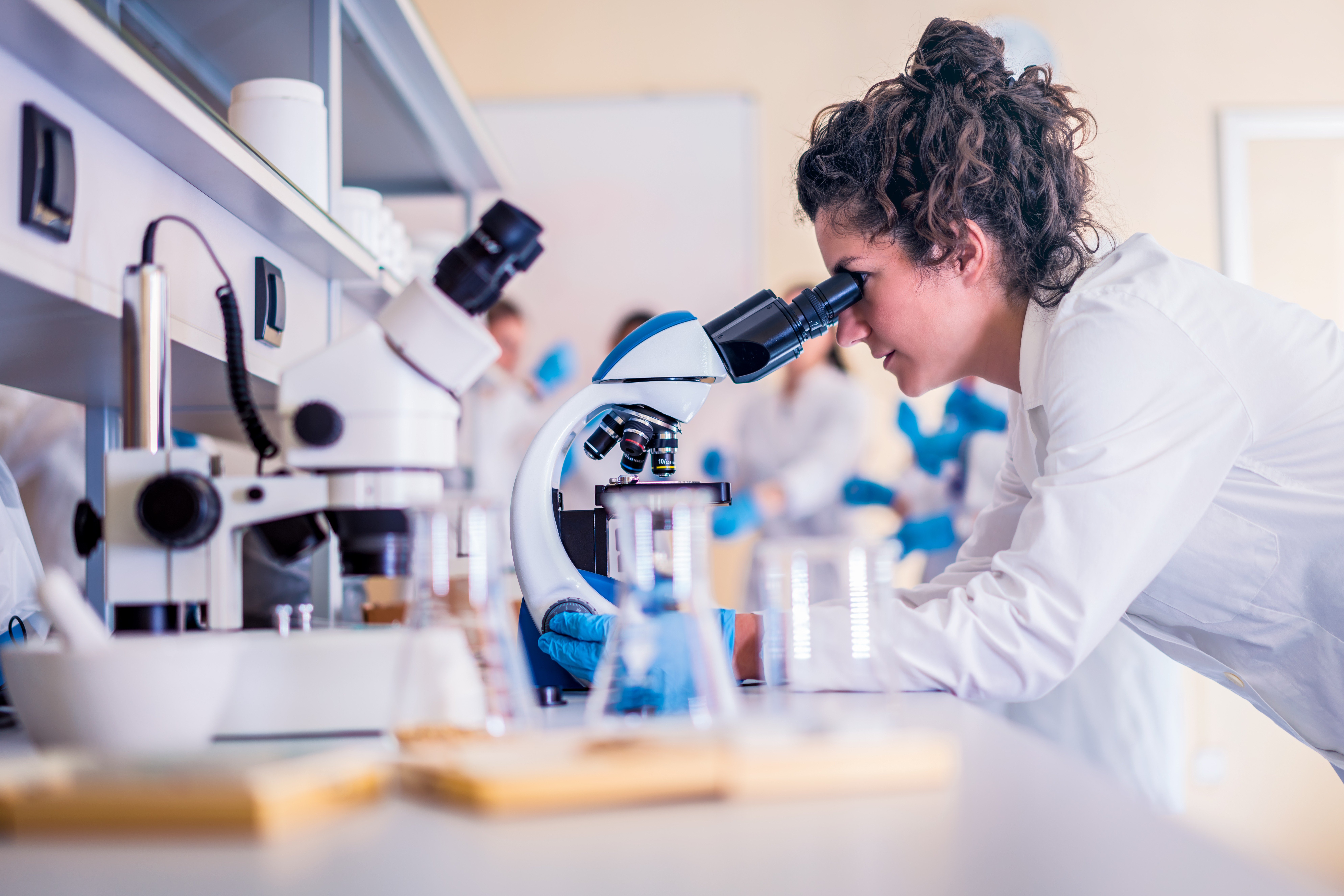 a young doctor conducting tests under a microscope