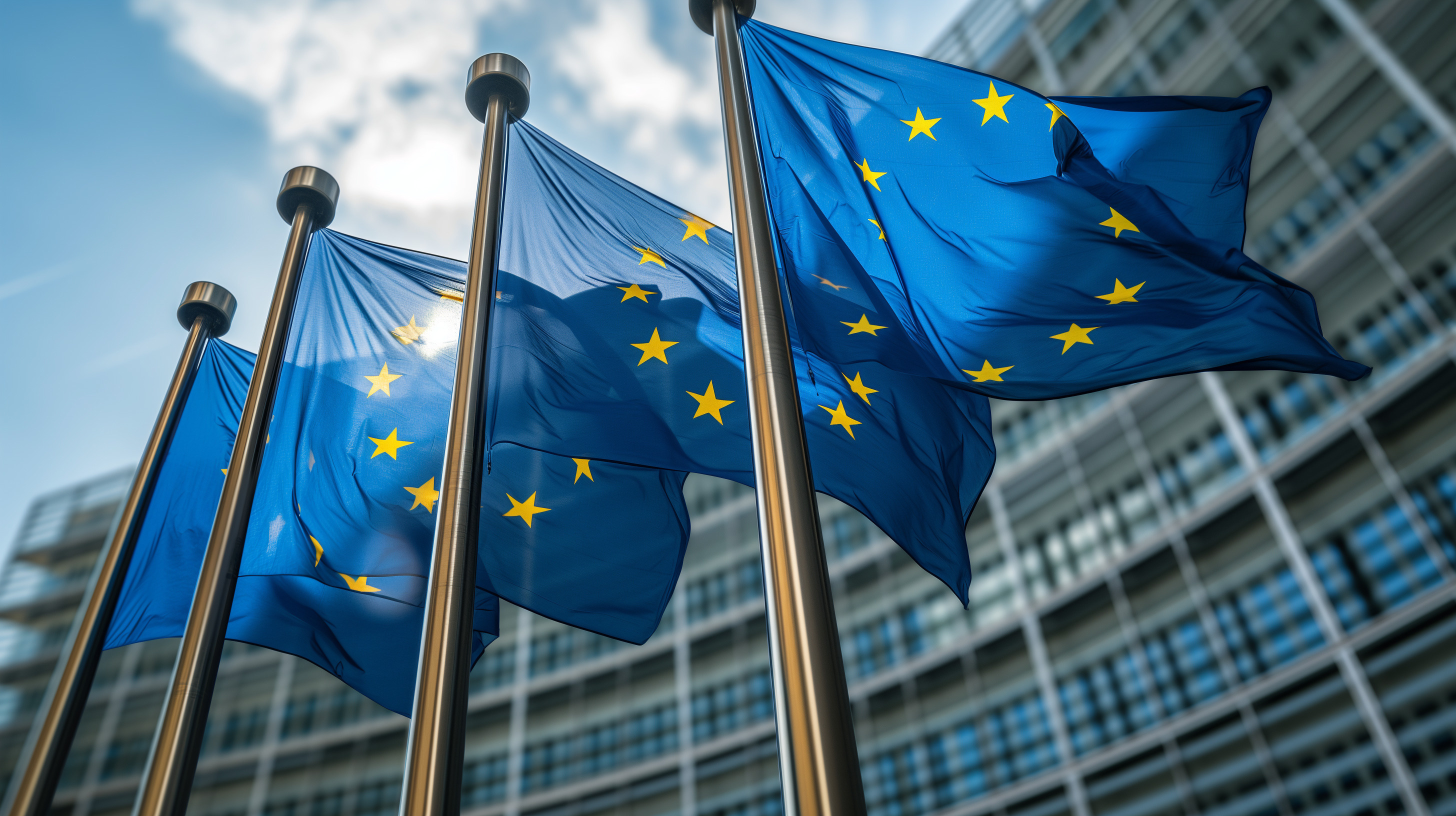European Union flags flying in front of a modern glass building