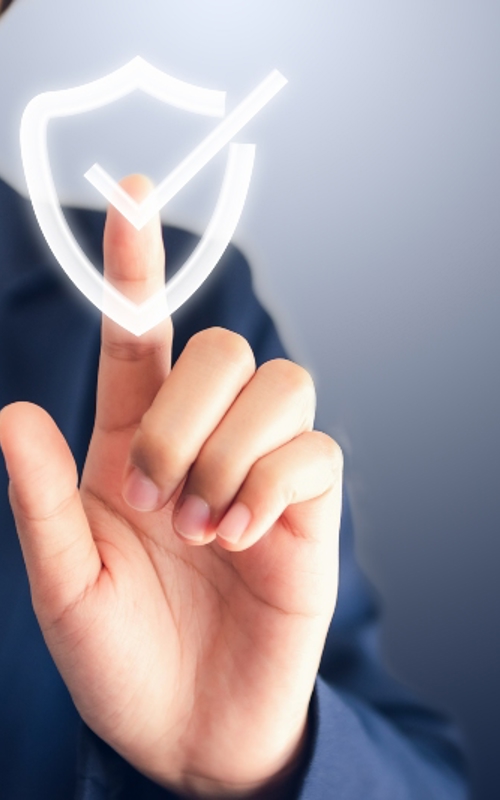 Person touching a digital shield icon with a checkmark, representing cybersecurity or data protection