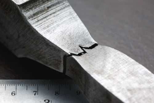 Metalli rikottuna viivoittimen päällä.