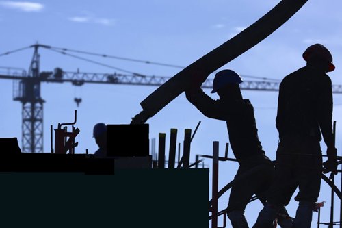 Silhouetten von Bauarbeitern mit Schutzhelmen auf einer Baustelle, im Hintergrund ein Baukran.
