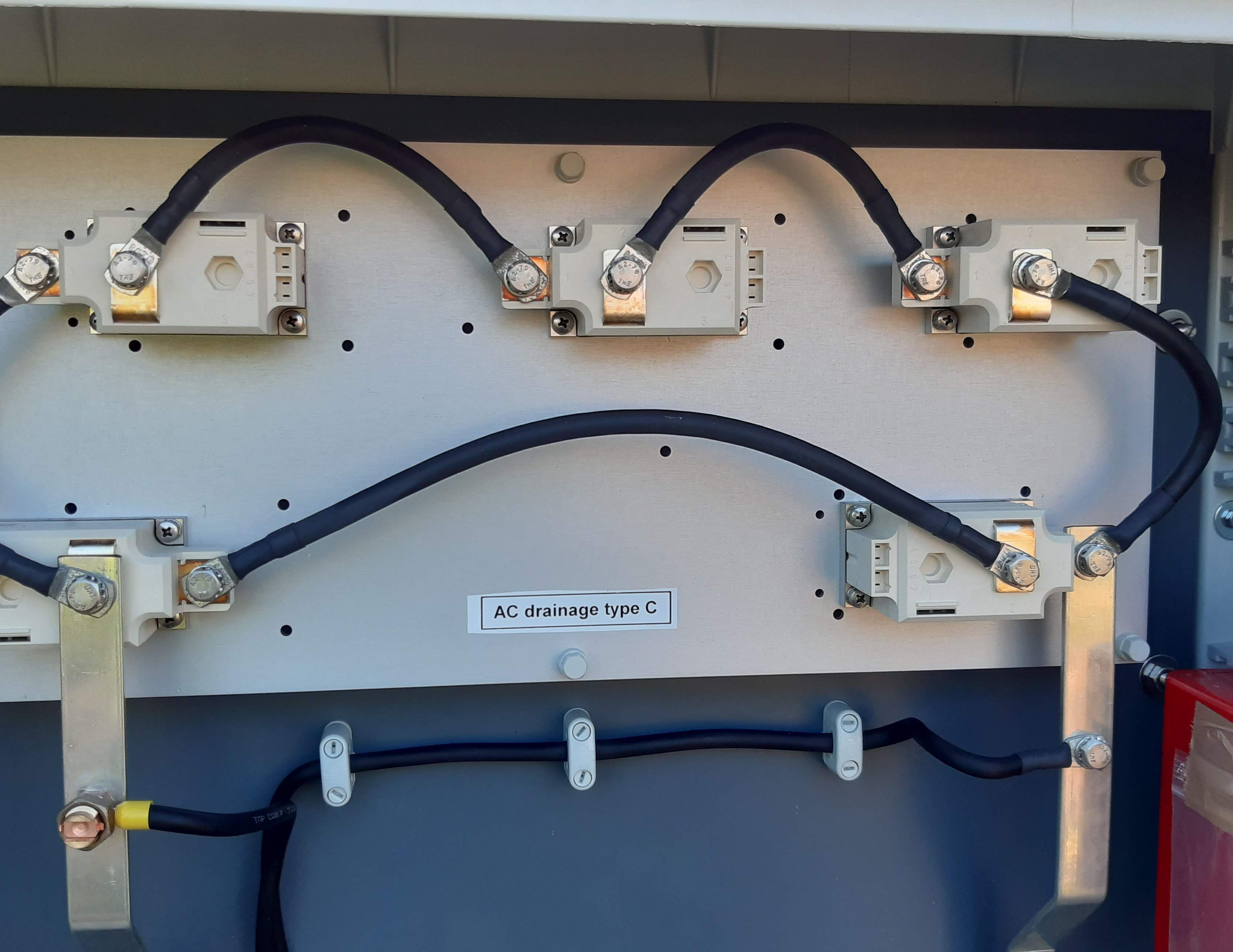 Elektrisch aansluitpaneel met meerdere zwarte kabels en het label ‘AC drainage type C’.