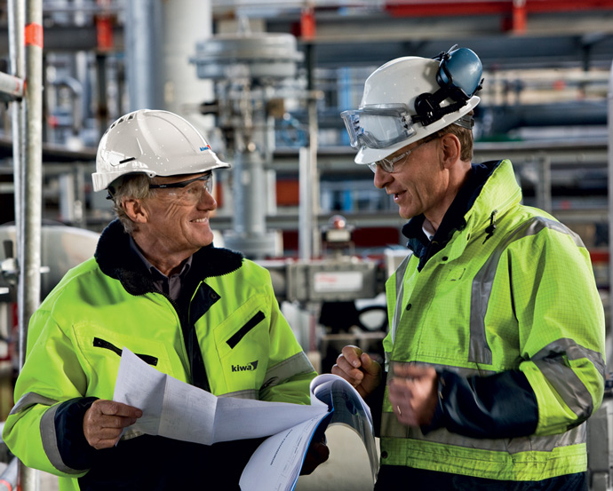 Kaksi miestä puhumassa työmaalla.