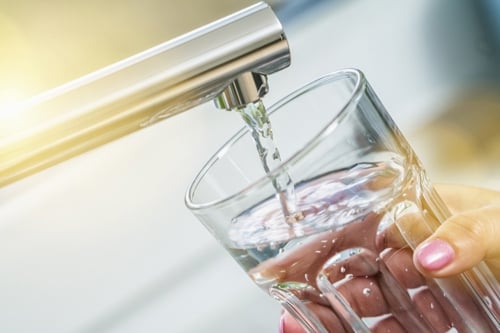 Tapping a glass of water in the kitchen