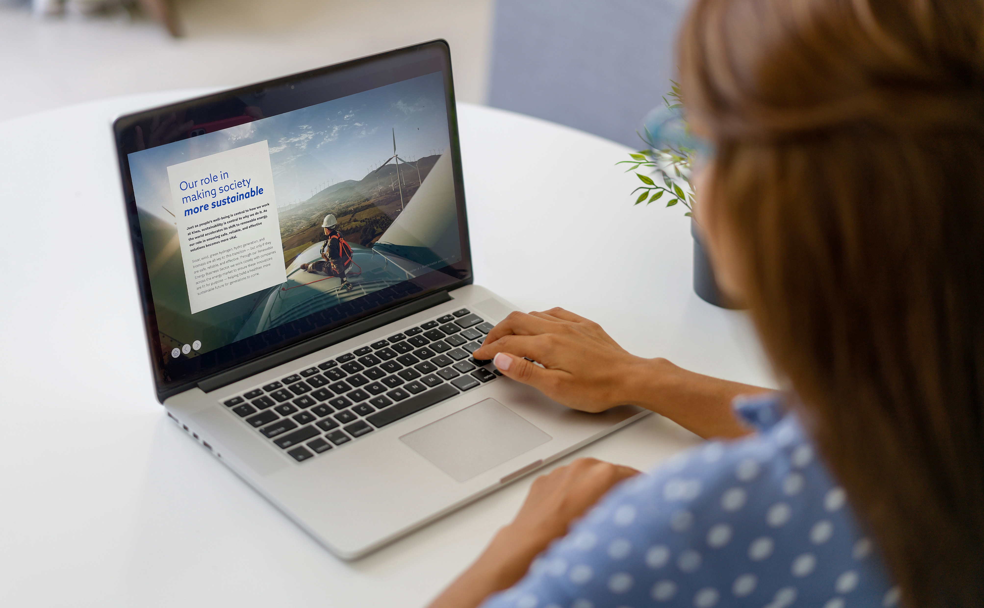  Close-up of a hand paging through Kiwa’s ESG report with sustainability data and impact highlights