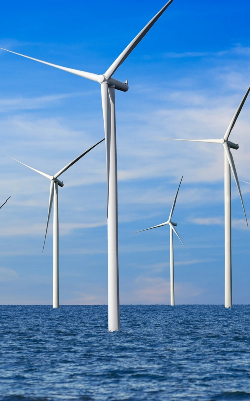 Offshore Kiwa inspected wind turbines in a calm ocean under a blue sky