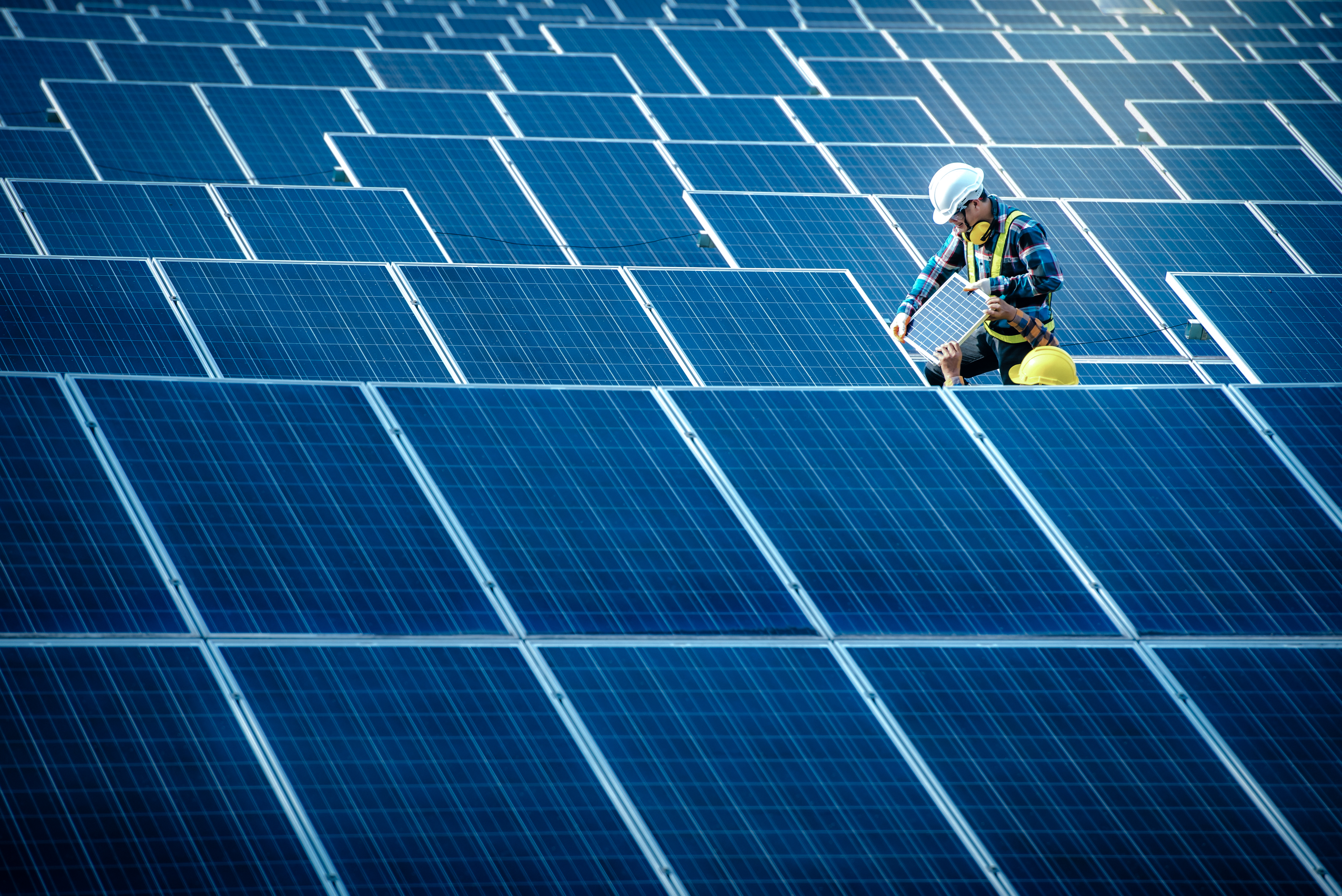 Kiwa inspectiors inspecting solar panels in a large photovoltaic solar farm