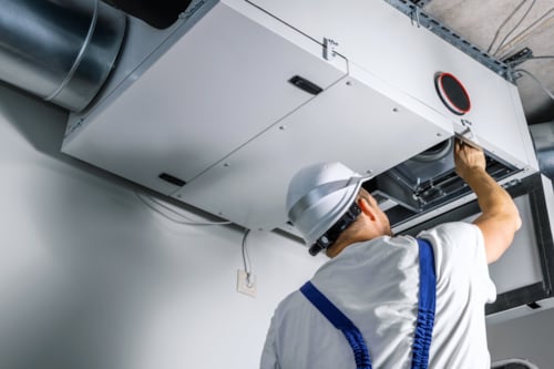 Besiktningsingenjör undersöker ventilationen i taket.