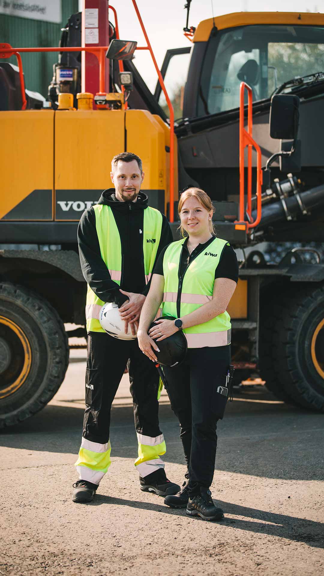 Två besiktningsingenjörer från Kiwa framför en entreprenadmaskin