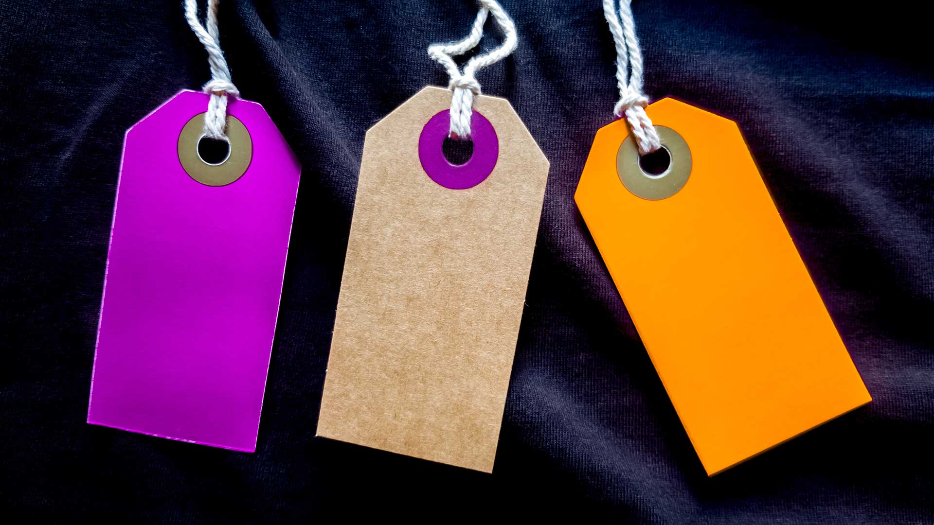 Blanka och tomma pappersetiketter i olika färger med ett knytsnöre, för märkning eller som pristaggar för produkter. 