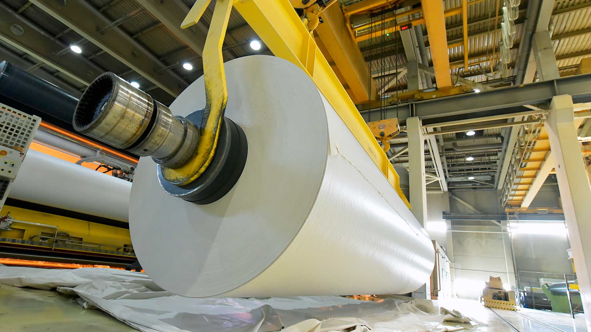 Produktion av papper i ett bruk - pappersrulle på en kran.