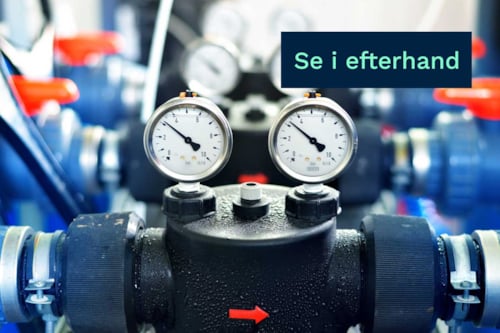 Närbild av två manometrar monterade på ett rörsystem, med en blå skylt som visar texten "se i efterhand".